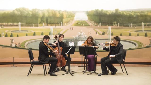 A string quartet performing in front of a large mural depicting a classical garden scene. The players are deeply engaged in their music. 设置, highlighted by the gr和 mural of a baroque garden with neatly trimmed hedges 和 statues, adds a formal 和 historic ambiance to their performance. The musicians, dressed in concert attire, enhance the elegant 和 artistic atmosphere of the scene.